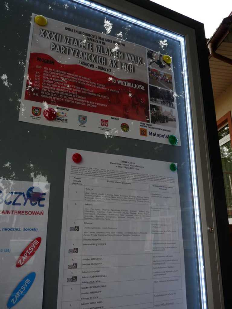 Solidna gablota z ramą z anodowanego aluminium, odporna na warunki atmosferyczne, z magnetycznym panelem tylnym i szybą ze szkła hartowanego lub akrylowego, z nowoczesnym profilem i stalowymi słupkami do wkopania, przeznaczona do użytku zewnętrznego.