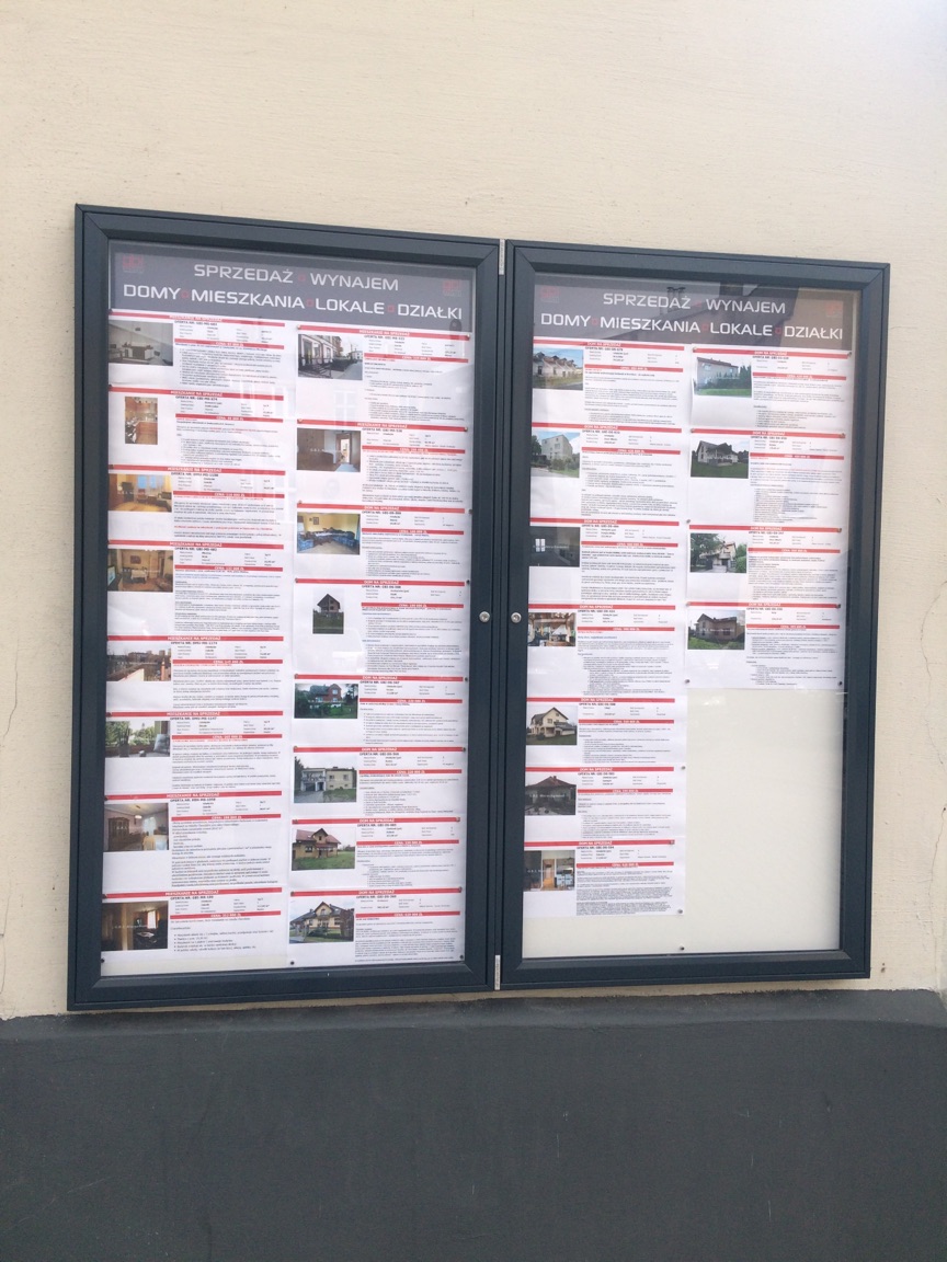 Dwudrzwiowa gablota naścienna z aluminiowym profilem ramy, z drzwiami zamykanymi na zamek osadzony w szybie, przeznaczona do użytku zewnętrznego.