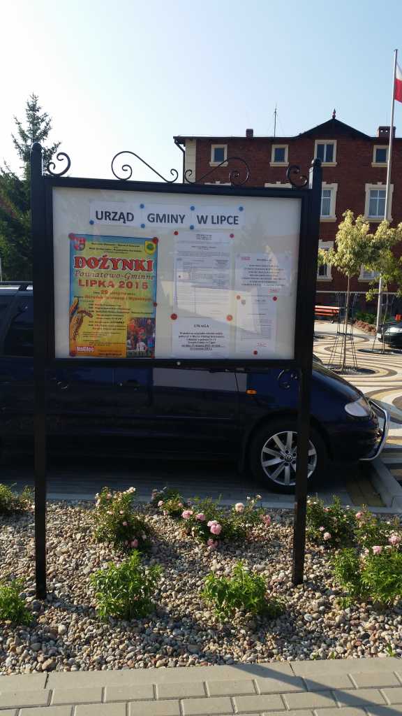 Duża, czarna, wolnostojąca gablota z jednoskrzydłowymi drzwiami, zamykana na klucz, przeznaczona do prezentacji ogłoszeń w przestrzeni publicznej.