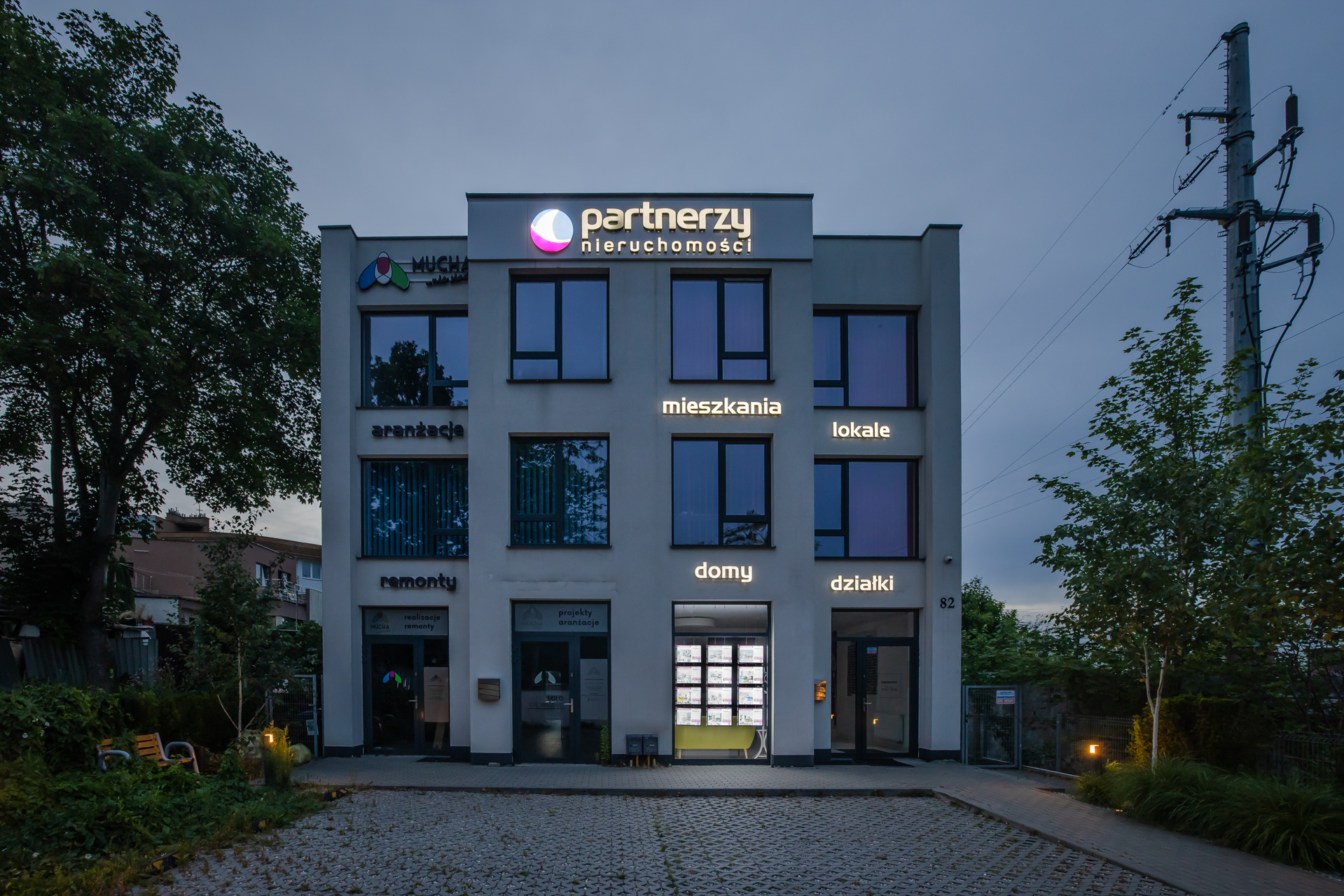 System witrynowy LED w biurze nieruchomości Partnerzy – ekspozycja widoczna po zmroku.