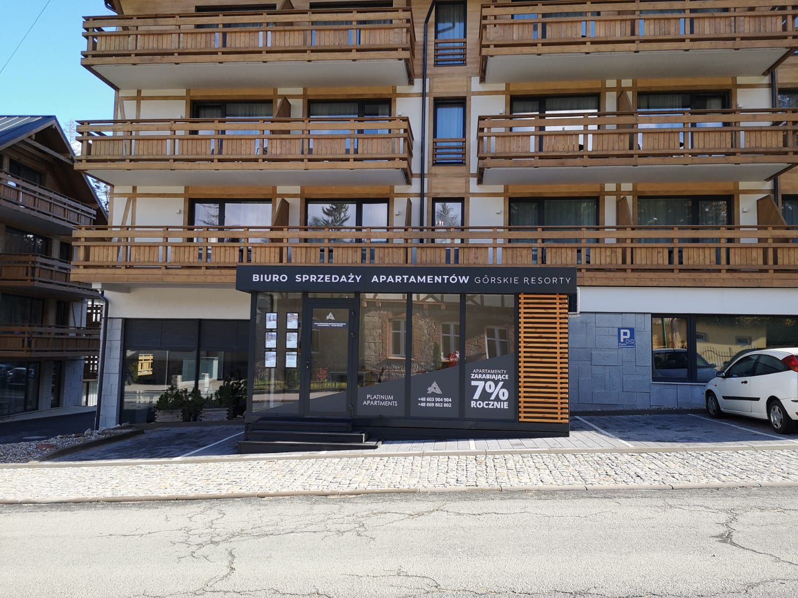 System LED w biurze sprzedaży apartamentów górskich – podświetlane ogłoszenia i oferta inwestycji.