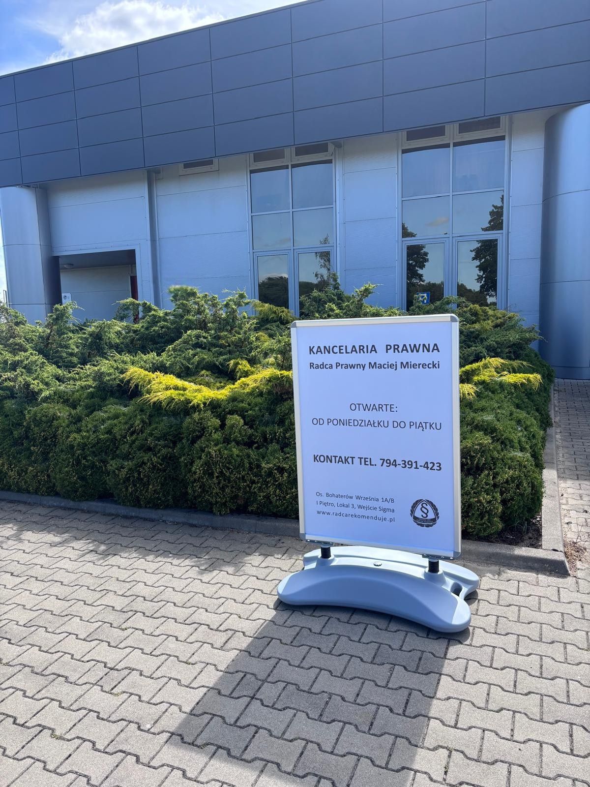 potykacz reklamowy z podstawą wodną przed kancelarią prawną